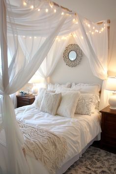 a white bed topped with lots of pillows and blankets