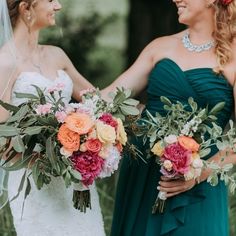 two bridesmaids holding bouquets and smiling at each other