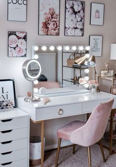 a vanity with a mirror and lights on it in front of some pink chairs next to a dresser