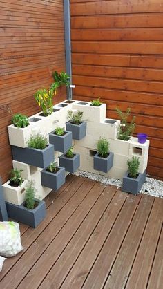 several planters are placed on the side of a building with wood flooring and wooden slats