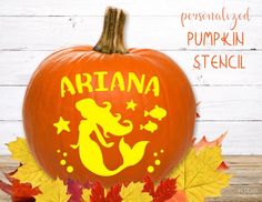 an orange pumpkin with the word ariana on it and leaves around it in front of a white wooden background