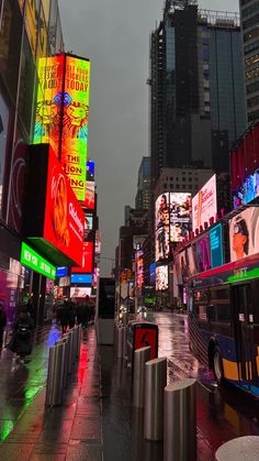 a city street filled with lots of neon signs and tall buildings on either side of it