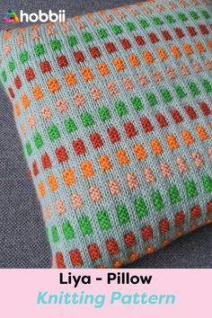 a knitted pillow sitting on top of a couch