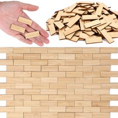 a hand is reaching for some wood pieces on the floor next to a pile of wooden blocks