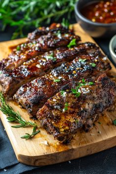 Grilled ribs garnished with herbs on a wooden board, served with a side of sauce. Cuban Mojo Pork, Cuban Pork Sandwich, Cuban Pork Roast, Cuban Mojo Marinated Pork, Recipes Burgers, Belizean Food, Cuban Mojo, Pork Roast Recipe, Pork Dinners