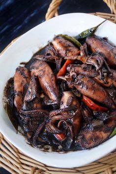 a white bowl filled with cooked squid and peppers