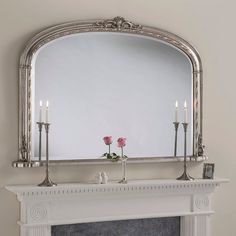 a fireplace with a mirror and candles on it