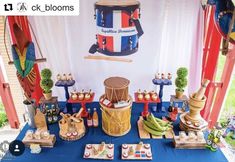 a blue table topped with lots of food and decor next to a red white and blue wall