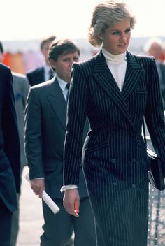 a woman in a pinstripe suit walking down the street