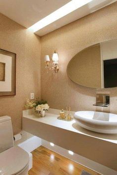 a white sink sitting under a bathroom mirror next to a wall mounted faucet