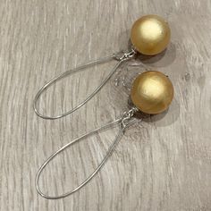 These handcrafted earrings are so pretty and unique!  18mm round glowing golden beads dangle from silver plated kidney hoops.  These earrings measure almost 2.75 inches in length.  Lightweight and FABULOUS Item is carefully packaged and shipped via USPS in a sturdy protective mailer. Check out more fabulous jewelry and enter my shop here: https://www.etsy.com/shop/jewelbytessyla View the positive feedback I've received from customers and check out some beautiful art prints for nursery and home a Handmade Drop Clip-on Earrings For Party, Gold Beaded Earrings With Pearl Drop For Party, Gold Pearl Drop Beaded Earrings For Party, Gold Nickel-free Beaded Earrings For Party, Handmade Pearl Drop Earrings For Party, Nickel Free Teardrop Clip-on Earrings For Party, Nickel-free Teardrop Clip-on Earrings For Party, Nickel-free Dangle Wrap Earrings For Party, Nickel Free Teardrop Earrings As Gift