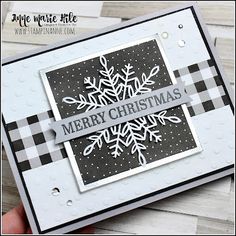 a hand holding up a christmas card with snowflakes on the front and bottom