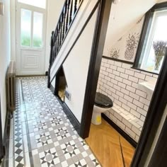 an open door leading to a bathroom with black and white tiles