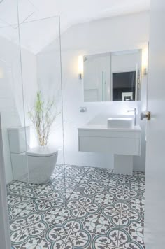 a bathroom with a toilet, sink and mirror in it's center wall is shown