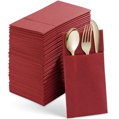 a stack of red napkins with gold forks and spoons in front of them