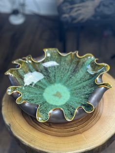 a green bowl sitting on top of a wooden table