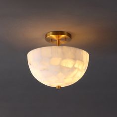 a light that is on the ceiling in a room with dark walls and flooring