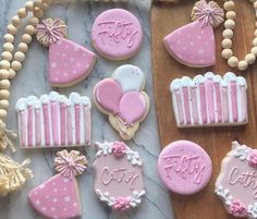 decorated cookies with pink and white icing are on a table next to other decorations