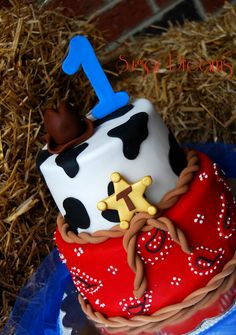 a birthday cake for a one year old with a cow on top and a number 1 on the side