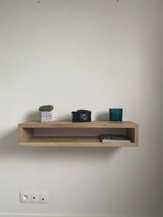 a wooden shelf with two plants on it