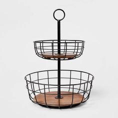 two tiered metal basket with wooden trays on each side and an iron handle