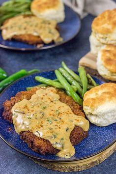 two blue plates topped with biscuits and green beans