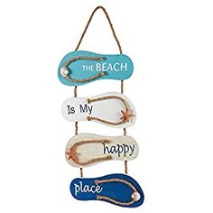 the beach is my happy place sign hanging on a rope with blue and white shoes