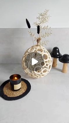 a table topped with a vase filled with flowers and mushrooms next to a candle holder