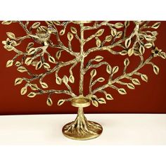 a golden metal tree sculpture on a white table