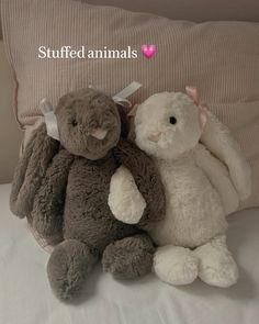 two stuffed animals sitting next to each other on a bed with the words stuffed animals above them