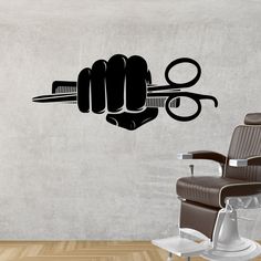 a wall decal that has scissors and combs on it in the shape of a fist