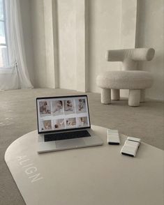 an open laptop computer sitting on top of a table next to a phone and remote control