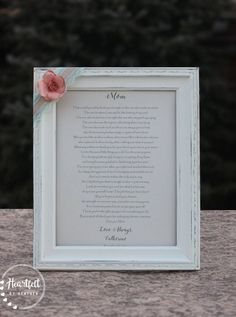 a white frame with a pink flower on it and a poem written in the middle