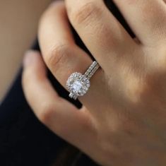 a woman's hand with a diamond ring on top of her finger and an engagement band