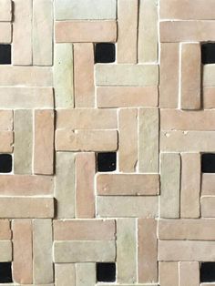 a close up view of a wall made out of small blocks of white and brown bricks