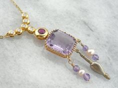 We crafted this one of a kind, unique necklace using pieces from a variety of eras! The center piece is an exquisite amethyst pendant that comes from the Art Nouveau era. We've added pearl and amethyst beads strung on gold wire, and an antique Victorian pendant to the base of this neat piece! The necklace we've chosen to finish this with is contemporary, with bezel set diamonds and a fine, deep red ruby at the center.Metal: 18k Yellow GoldGemstone: Amethyst Gem Measurements: 13.4 x 12.1 mm, Rect Luxury Purple Pendant Necklace, Luxury Multi-stone Amethyst Necklace, Luxury Amethyst Multi-stone Necklace, Exquisite Amethyst Pendant Necklace, Elegant Purple Multi-stone Necklaces, Elegant Purple Multi-stone Necklace, Luxury Amethyst Necklace With Gemstone Accents, Luxury Yellow Gold Amethyst Necklace, Formal Multi-stone Amethyst Necklaces