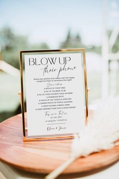 a close up of a sign on a table with a white feather in it's hand