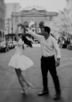 a man and woman are dancing in the street