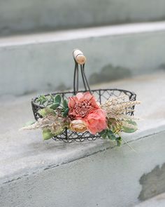 a basket with flowers on it sitting on some steps