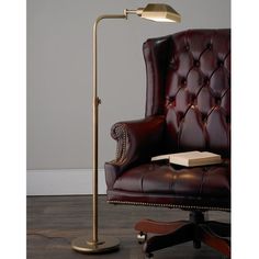 a lamp that is on top of a table next to a chair and a book