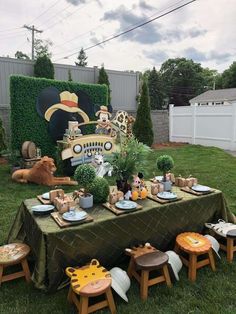 a table set up with plates, cups and other items on it in the yard