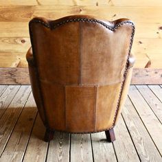 a brown leather chair sitting on top of a wooden floor