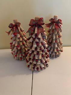 three wine cork christmas trees with bows on them