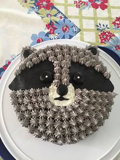 there is a cake that looks like a raccoon on the plate with flowers