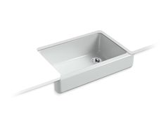 a white sink sitting on top of a counter next to a wall mounted faucet