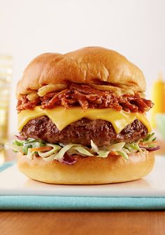 a cheeseburger with meat and lettuce on a bun