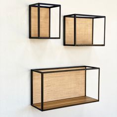 two wall mounted shelves with bamboo shades on them