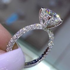 a close up of a person holding a diamond ring