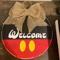 a mickey mouse welcome sign with a bow