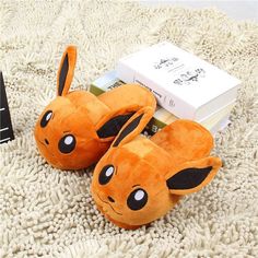 a pair of pokemon slippers sitting on top of a white rug next to a book